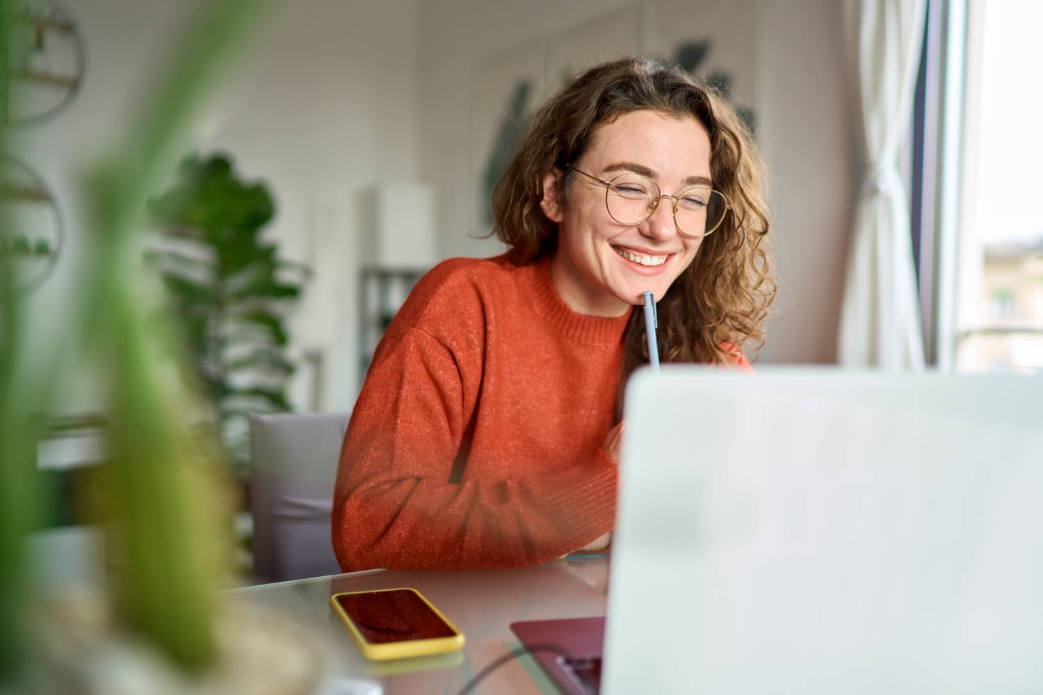 Smiling woman watching webinar on laptop