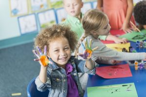 preschool girl gets her hands dirty with fingerpainting, similar to adults doing self-service data preparation