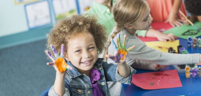 preschool girl gets her hands dirty with fingerpainting, similar to adults doing self-service data preparation