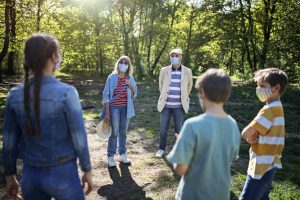 Family meets outdoors and socially distanced with masks during coronavirus