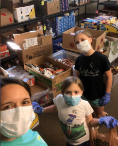 Amanda and her daughters volunteering 