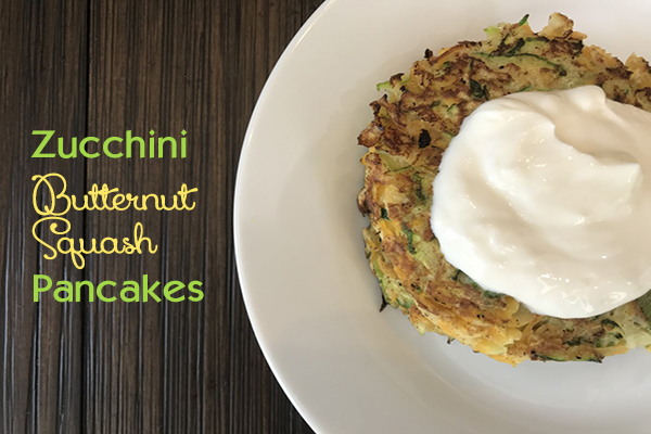 overhead view of a stack of zucchini butternut squash pancakes topped with greek yogurt on a white plate