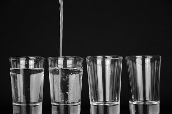 four clear glass being filled with water