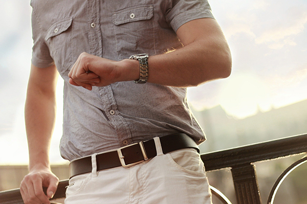 torso of man looking at his wrist watch