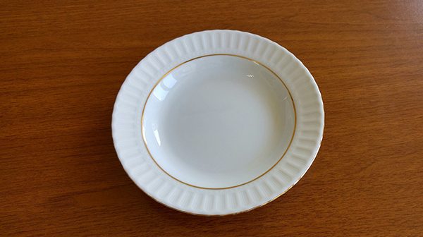 empty white plate on wooden surface