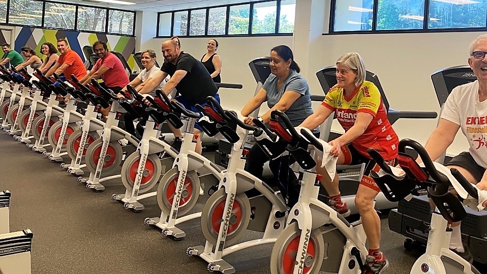 Employees riding stationary bikes and walking on treadmills