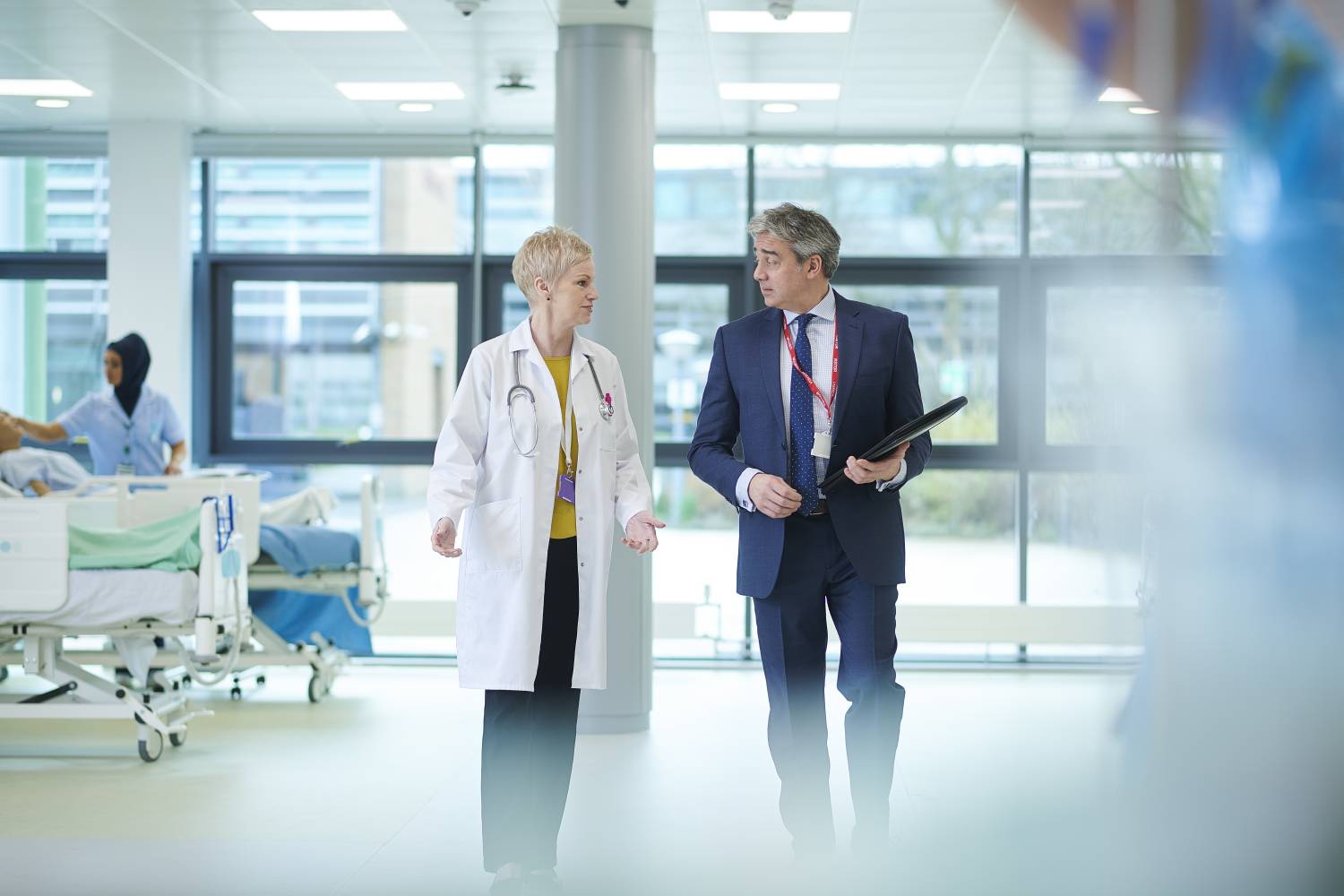 doctor and businessman walking through hospital