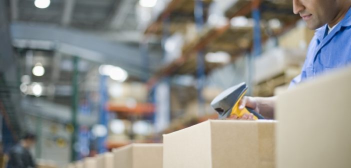 Man scanning boxes in warehouse