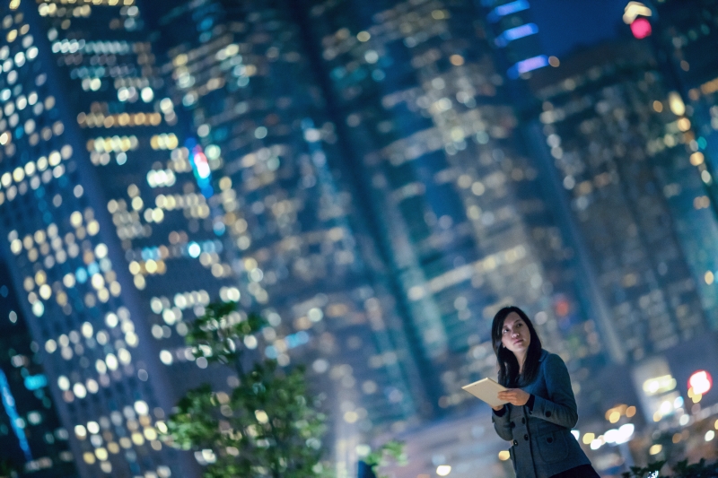 modern woman in front of tall, modern buildings