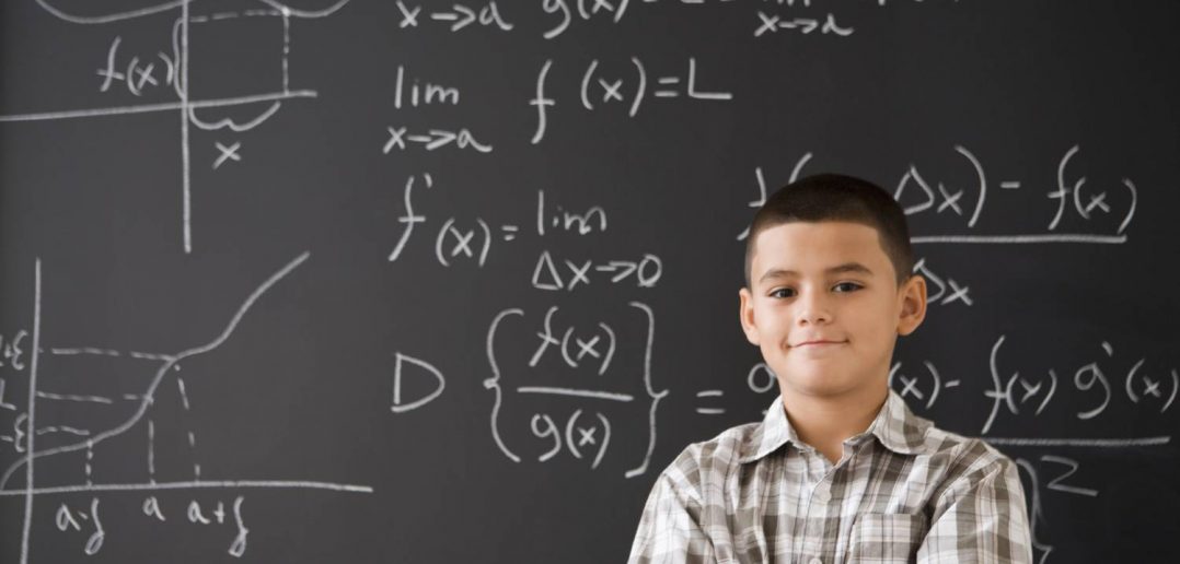 Young man standing in front of chalkboard with statistical functions