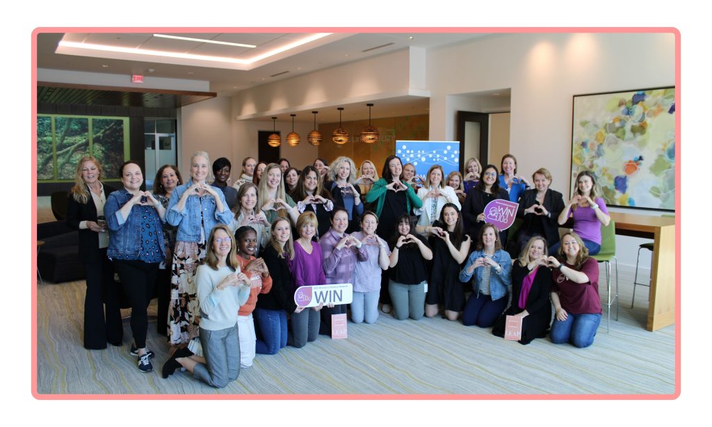 A group of employees celebrate International Women's Day by holding their hands in the shape of a heart.