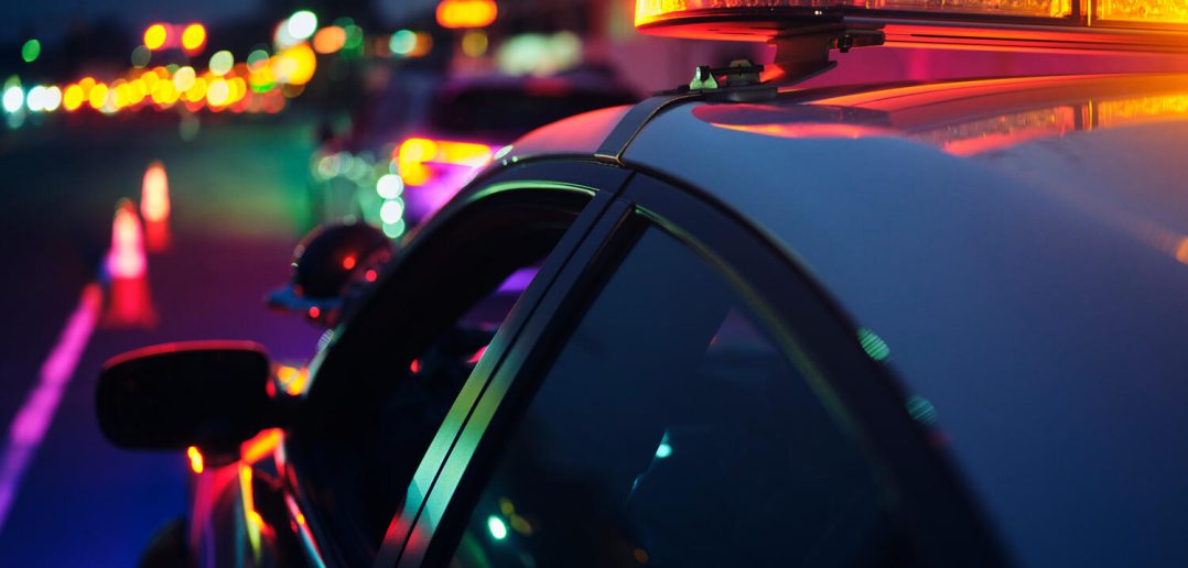 A police car stopping a vehicle at night.
