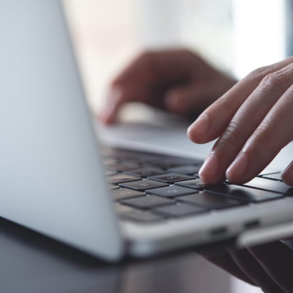 Close up of business woman hands typing on laptop keyboard on table, online working from home office, searching the information on internet network, e-learning, telecommuting concept