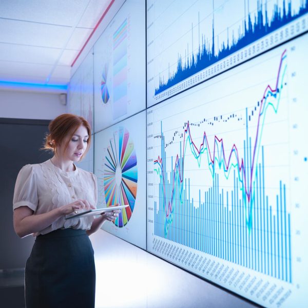 Businesswoman studying graphs on screen with digital tablet