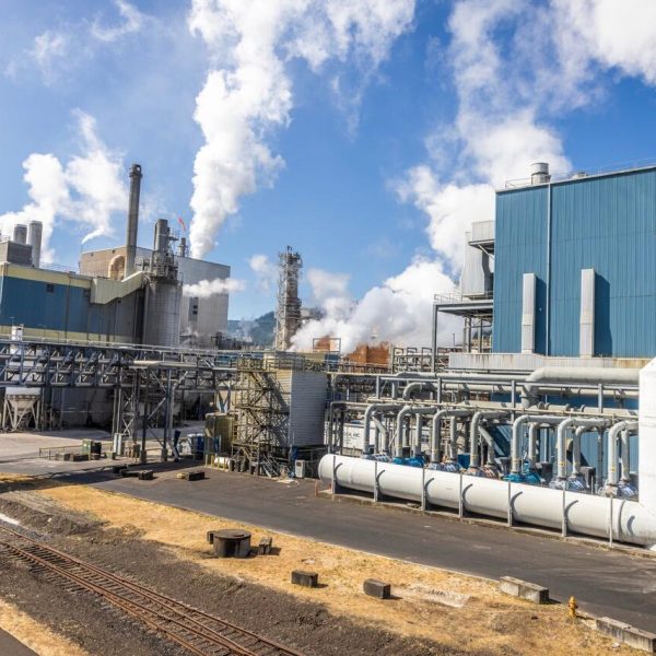 Entire industrial plant with smoke rising out of stacks.