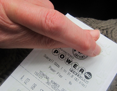 Powerball lottery ticket, and fingers crossed for luck.